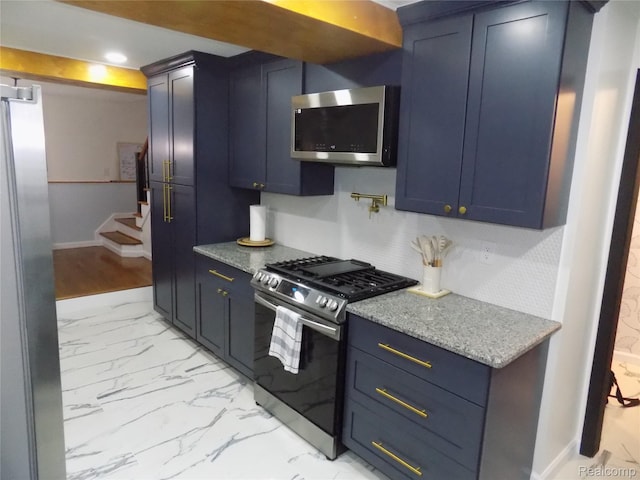 9207 Whitall Ln, Trenton, MI 48138 - kitchen featuring stainless steel appliances, blue cabinetry, light marble finish flooring, and baseboards
