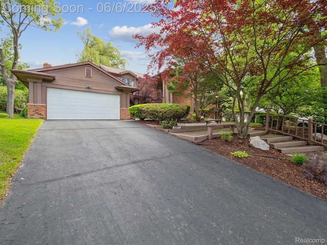 4677 Rolling Ridge Rd, West Bloomfield, MI 48323 - view of front facade with brick siding, driveway, a chimney, and a garage