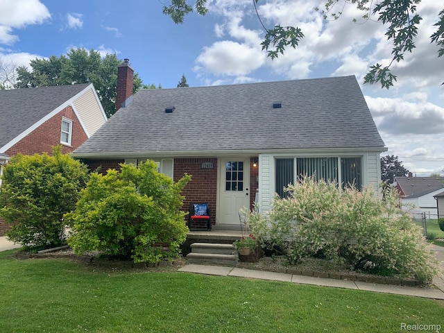 17439 Brody Ave, Allen Park, MI 48101 - view of front of house with a front lawn, a shingled roof, brick siding, and a chimney