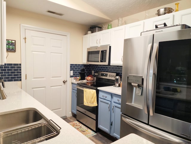 324 Ashley Ct Unit 10, Brooklyn, MI 49230 - kitchen featuring appliances with stainless steel finishes, a sink, light countertops, backsplash, and a textured ceiling