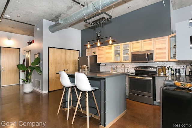 55 W Canfield Unit 210, Detroit, MI 48201 - kitchen with appliances with stainless steel finishes, a towering ceiling, finished concrete floors, and decorative backsplash