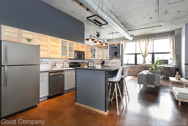55 W Canfield Unit 210, Detroit, MI 48201 - kitchen with appliances with stainless steel finishes, concrete flooring, backsplash, a sink, and dark countertops