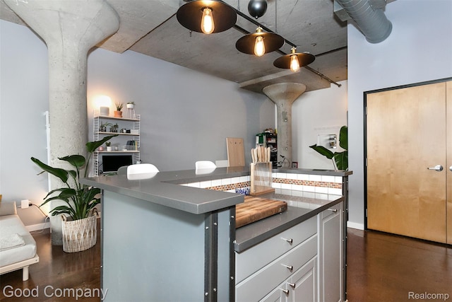 55 W Canfield Unit 210, Detroit, MI 48201 - kitchen featuring dark countertops, white cabinetry, concrete flooring, and baseboards