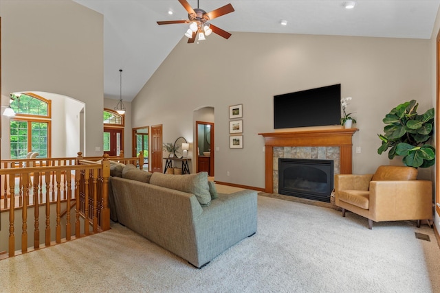 11082 Hoffman Rd, Marcellus, MI 49067 - carpeted living area featuring high vaulted ceiling, ceiling fan, a fireplace, arched walkways, and baseboards