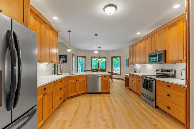 11082 Hoffman Rd, Marcellus, MI 49067 - kitchen featuring appliances with stainless steel finishes, light wood-type flooring, a peninsula, tasteful backsplash, and recessed lighting