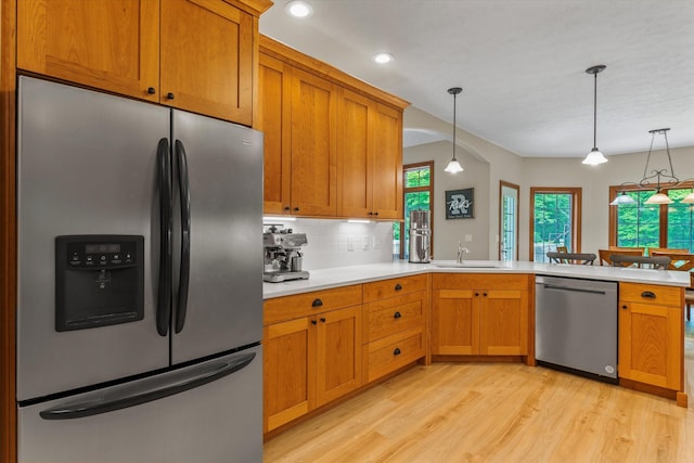 11082 Hoffman Rd, Marcellus, MI 49067 - kitchen with stainless steel appliances, light wood finished floors, light countertops, tasteful backsplash, and pendant lighting