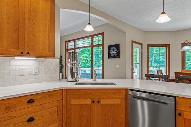 11082 Hoffman Rd, Marcellus, MI 49067 - kitchen with stainless steel dishwasher, a sink, light countertops, decorative backsplash, and hanging light fixtures