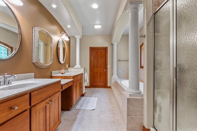 11082 Hoffman Rd, Marcellus, MI 49067 - full bathroom featuring ornate columns, two vanities, a shower stall, and a garden tub