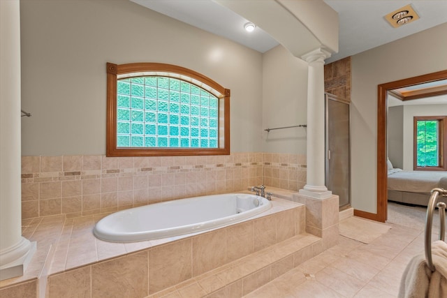 11082 Hoffman Rd, Marcellus, MI 49067 - ensuite bathroom with ornate columns, a garden tub, a stall shower, and tile patterned floors