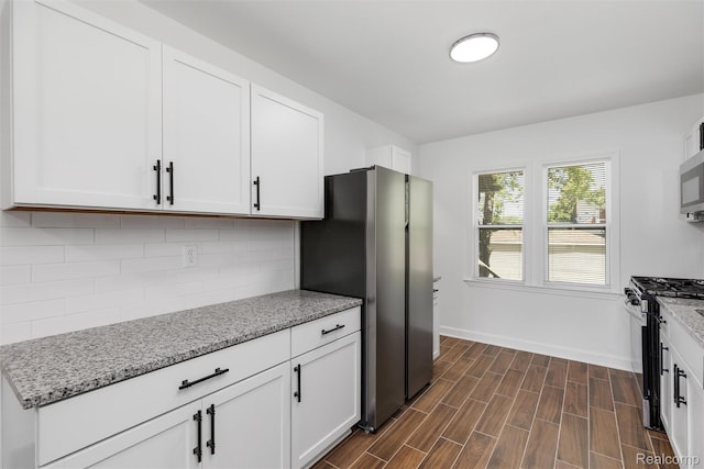 7505 E Robinwood St, Detroit, MI 48234 - kitchen with stainless steel appliances, decorative backsplash, white cabinetry, and light stone countertops