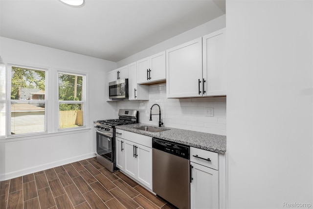 7505 E Robinwood St, Detroit, MI 48234 - kitchen featuring stainless steel appliances, a sink, light stone countertops, baseboards, and decorative backsplash
