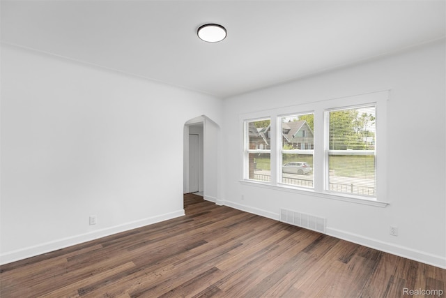 7505 E Robinwood St, Detroit, MI 48234 - spare room featuring arched walkways, wood finished floors, and baseboards