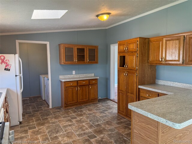 59227 Lewis Ln, New Haven, MI 48048 - kitchen with freestanding refrigerator, washer and dryer, brown cabinets, light countertops, and dark stone finish floors