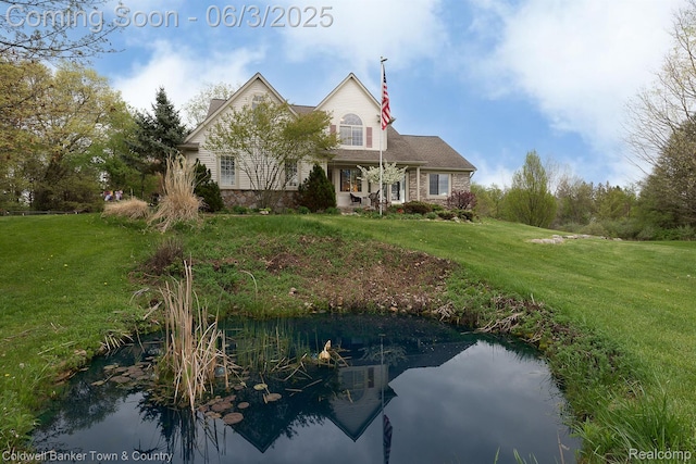 1355 Maxfield Rd, Brighton, MI 48114 - view of front facade with a front lawn, a chimney, and a small pond