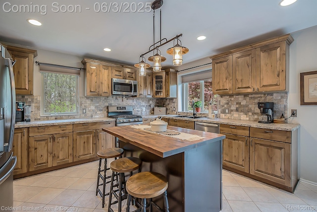 1355 Maxfield Rd, Brighton, MI 48114 - kitchen with stainless steel appliances, wood counters, light tile patterned flooring, a sink, and backsplash