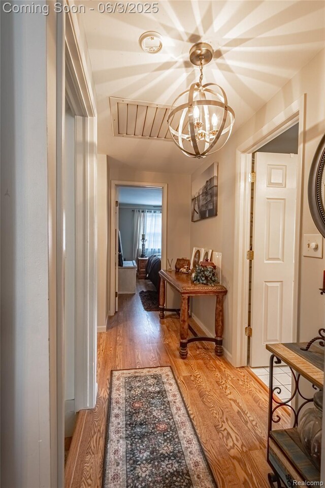 527 Montana St, Marysville, MI 48040 - hallway with a chandelier, light wood-type flooring, and baseboards