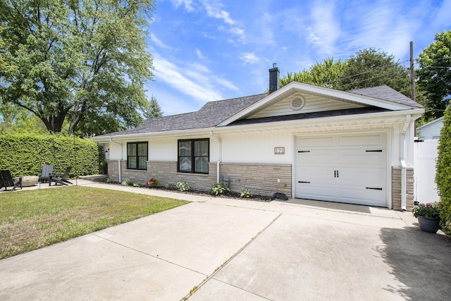 121 S Barker St, New Buffalo, MI 49117 - ranch-style home featuring stone siding, concrete driveway, a front lawn, a garage, and a chimney