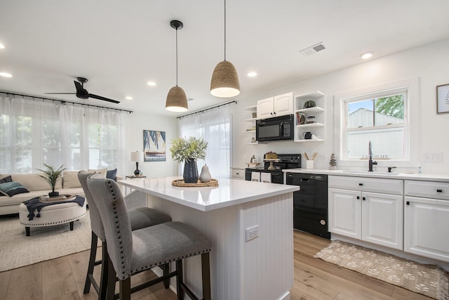 121 S Barker St, New Buffalo, MI 49117 - kitchen featuring black appliances, open shelves, a kitchen breakfast bar, a sink, and a kitchen island