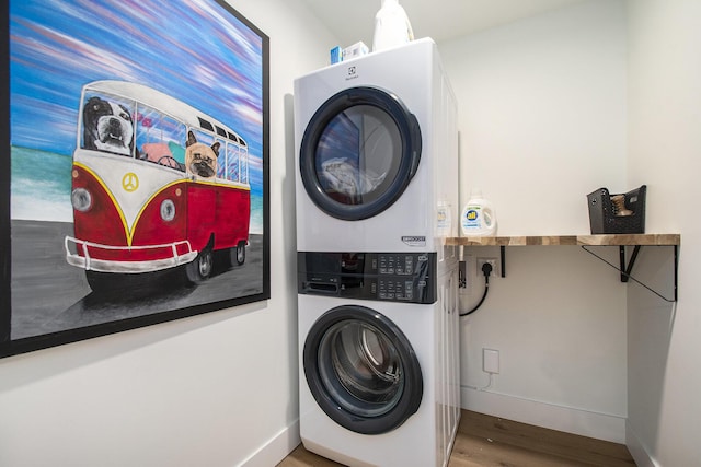 121 S Barker St, New Buffalo, MI 49117 - laundry room featuring stacked washer and clothes dryer, wood finished floors, and baseboards