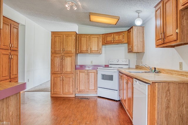 3490 Luce Rd, Flushing, MI 48433 - kitchen with white appliances, a sink, light countertops, light wood finished floors, and vaulted ceiling