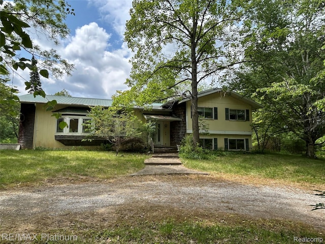 2625 Preston Ln, Howell, MI 48855 - tri-level home with a metal roof, driveway, and a front lawn