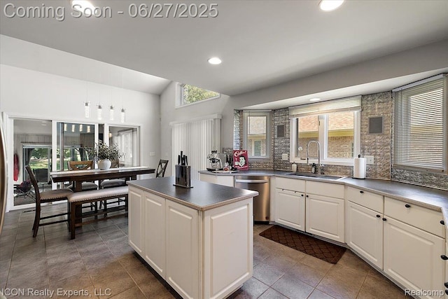 18529 Sumpter Forest Dr, Macomb, MI 48042 - kitchen featuring stainless steel dishwasher, a kitchen island, vaulted ceiling, dark tile patterned flooring, and dark countertops