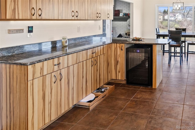 254 Cross Timbers St, Oxford, MI 48371 - kitchen with beverage cooler, dark tile patterned floors, a peninsula, light brown cabinetry, and dark stone countertops
