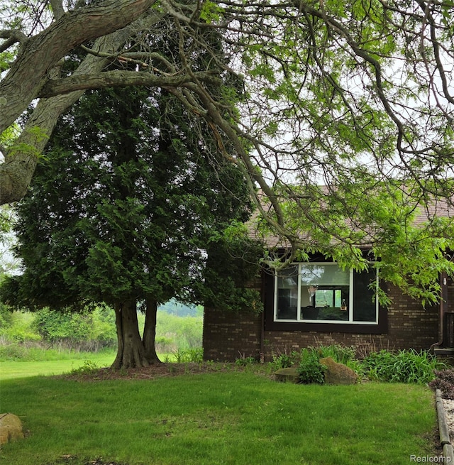 254 Cross Timbers St, Oxford, MI 48371 - view of home's exterior featuring brick siding and a lawn