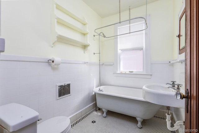 17173 New York St, Detroit, MI 48224 - full bath featuring tile walls, toilet, tile patterned floors, a sink, and a wainscoted wall