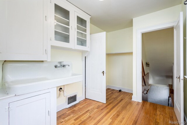 17173 New York St, Detroit, MI 48224 - kitchen featuring glass insert cabinets, light countertops, white cabinets, and light wood finished floors