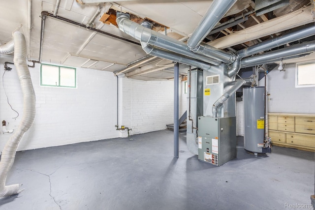 17173 New York St, Detroit, MI 48224 - below grade area with gas water heater, plenty of natural light, heating unit, and brick wall