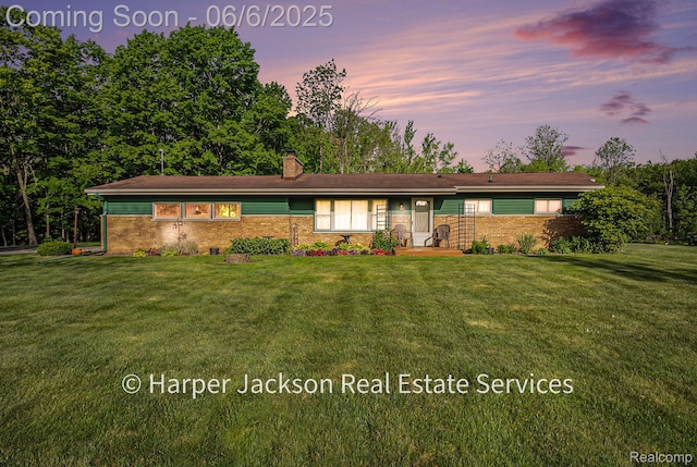 2210 Brookhaven Dr, Flint, MI 48507 - view of front of house featuring brick siding, a chimney, and a yard