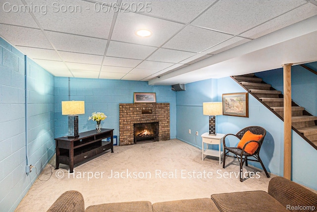 2210 Brookhaven Dr, Flint, MI 48507 - living room with carpet, a paneled ceiling, stairway, concrete block wall, and a fireplace
