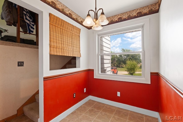 4460 Munger Rd, Tipton, MI 49287 - unfurnished dining area with a chandelier, tile patterned floors, baseboards, and stairway