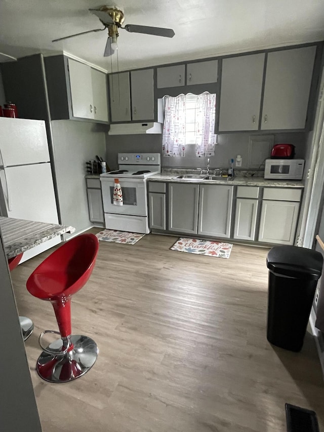 35511 Beverly Rd, Romulus, MI 48174 - kitchen with white appliances, gray cabinetry, under cabinet range hood, a sink, and ceiling fan