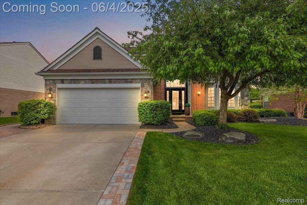 54502 Isle Royale Ave, Macomb, MI 48042 - view of front of house featuring concrete driveway, a front yard, stone siding, and a garage