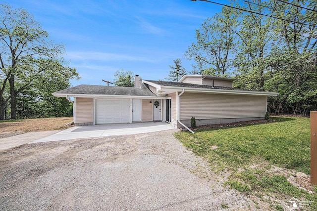 2930 Spielman Rd, Adrian, MI 49221 - view of front of home with driveway, a front yard, an attached garage, and a chimney