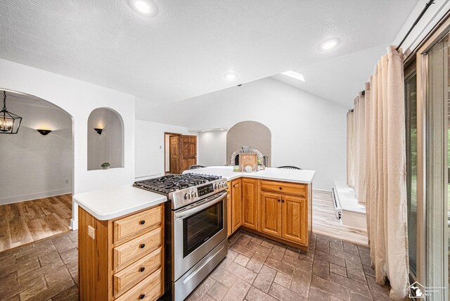 2930 Spielman Rd, Adrian, MI 49221 - kitchen featuring gas stove, vaulted ceiling, light countertops, recessed lighting, and arched walkways