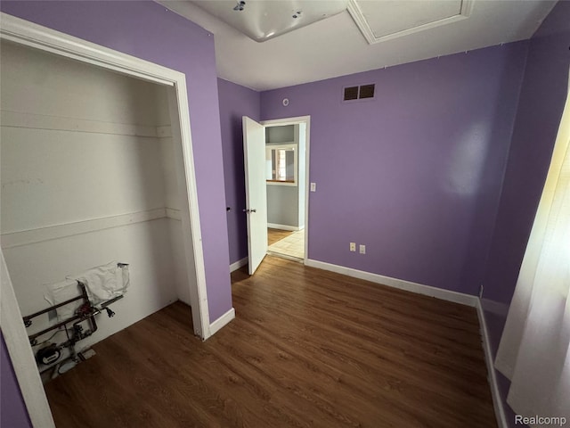 6194 Wilson Dr, Waterford, MI 48329 - unfurnished bedroom with wood finished floors, attic access, a closet, and baseboards