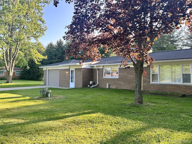 205 Sterling Dr, Lapeer, MI 48446 - view of front of house with an attached garage, a front yard, brick siding, and driveway