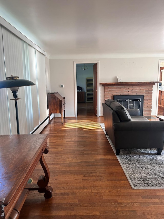 205 Sterling Dr, Lapeer, MI 48446 - living area featuring baseboard heating, a brick fireplace, wood finished floors, and baseboards