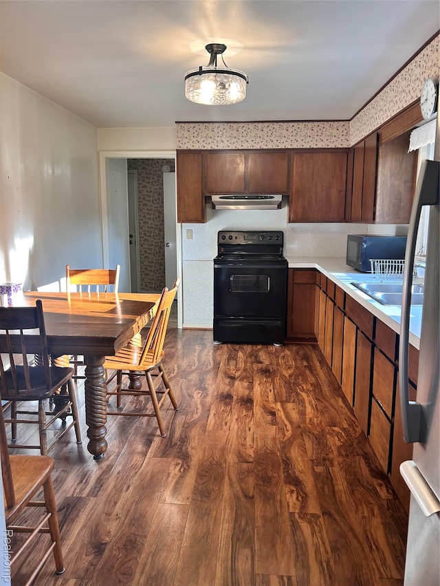205 Sterling Dr, Lapeer, MI 48446 - kitchen featuring black appliances, dark wood finished floors, light countertops, exhaust hood, and dark brown cabinetry