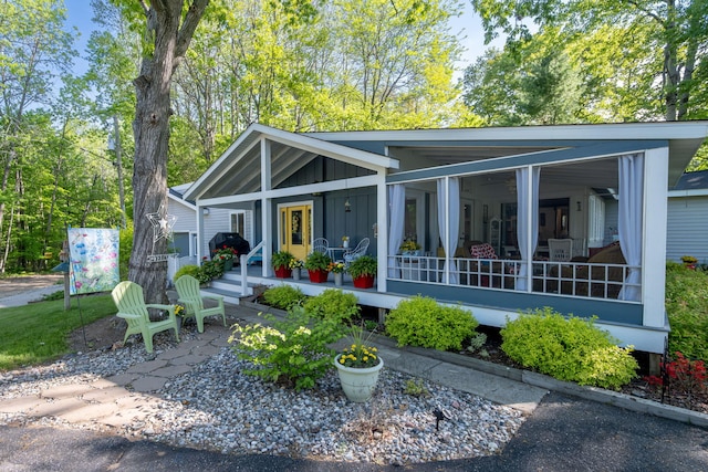 11198 E Royal Rd, Canadian Lakes, MI 49346 - view of front of home with board and batten siding and a sunroom