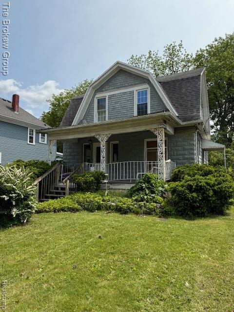 619 W Barnes Ave, Lansing, MI 48910 - view of front of property with a gambrel roof, a front yard, covered porch, and roof with shingles