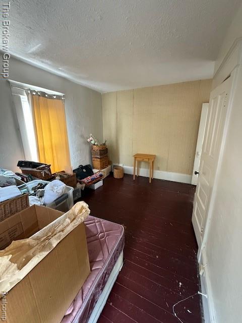 619 W Barnes Ave, Lansing, MI 48910 - bedroom with wood-type flooring, a textured ceiling, and baseboards