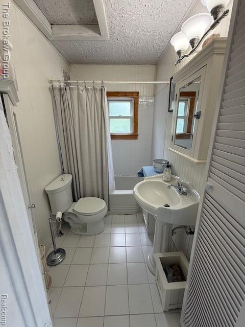 619 W Barnes Ave, Lansing, MI 48910 - full bath featuring toilet, tile patterned floors, a textured ceiling, and shower / tub combo