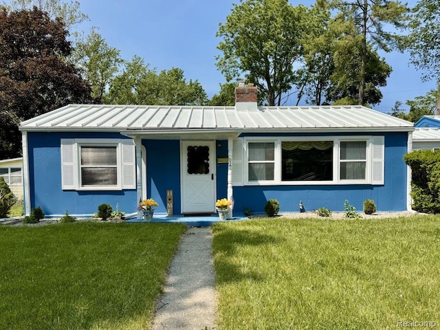 612 Cressfield Ln, Ann Arbor, MI 48103 - view of front of property with a chimney, a standing seam roof, a front lawn, and metal roof