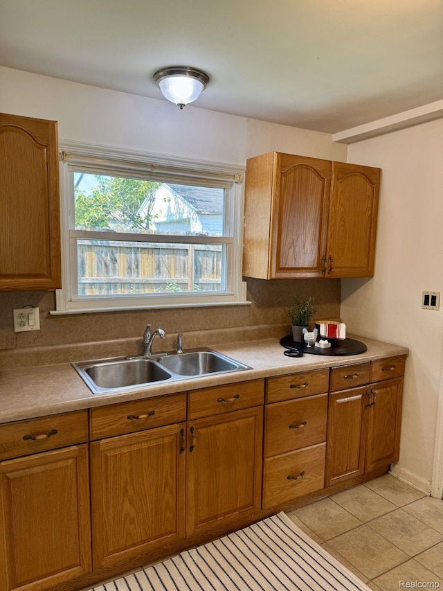 612 Cressfield Ln, Ann Arbor, MI 48103 - kitchen with a sink, brown cabinetry, light tile patterned flooring, and light countertops