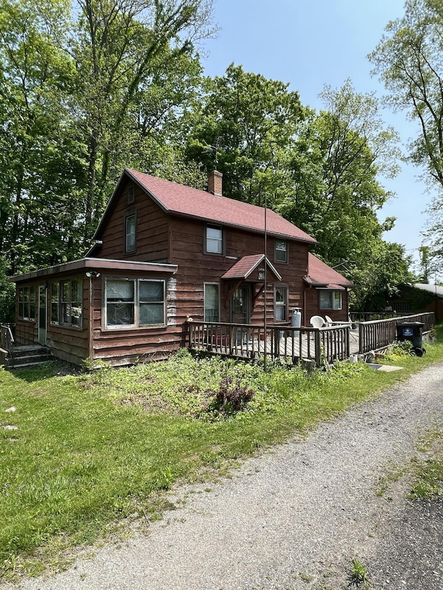 7530 Warren Woods Rd, Three Oaks, MI 49128 - view of front of house with a chimney and a wooden deck