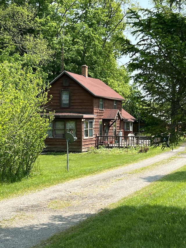 7530 Warren Woods Rd, Three Oaks, MI 49128 - view of front of house with a chimney, a front yard, and driveway